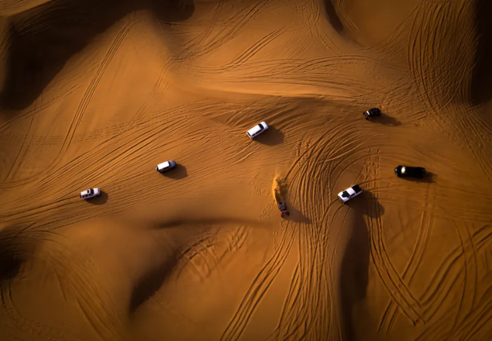 Convoy of 4x4s dune bashing seen from above