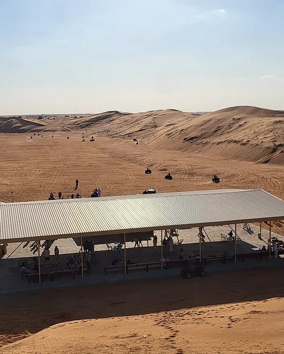 Quad bikes riding across the red dunes beside our Lahbab desert camp